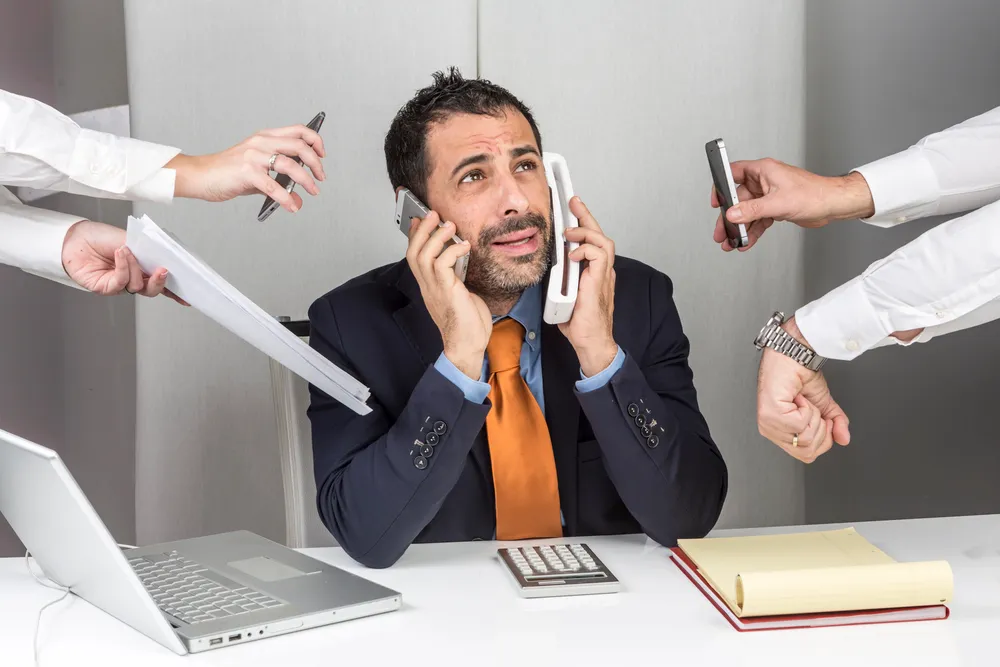 L'immagine rappresenta brillantemente la realtà di ogni imprenditore o manager moderno: essere costantemente sotto pressione, dover gestire molteplici richieste simultanee e la sensazione di non avere mai abbastanza tempo. Le mani che convergono verso il protagonista simboleggiano le infinite richieste di attenzione che caratterizzano il business contemporaneo. La cravatta arancione diventa un punto focale che suggerisce personalità e energia, mentre l'espressione del volto comunica la determinazione di chi sa gestire situazioni complesse. È una metafora perfetta per rappresentare la necessità di soluzioni che semplifichino la vita professionale, come un buon consulente SEO che si occupi autonomamente dell'ottimizzazione online.